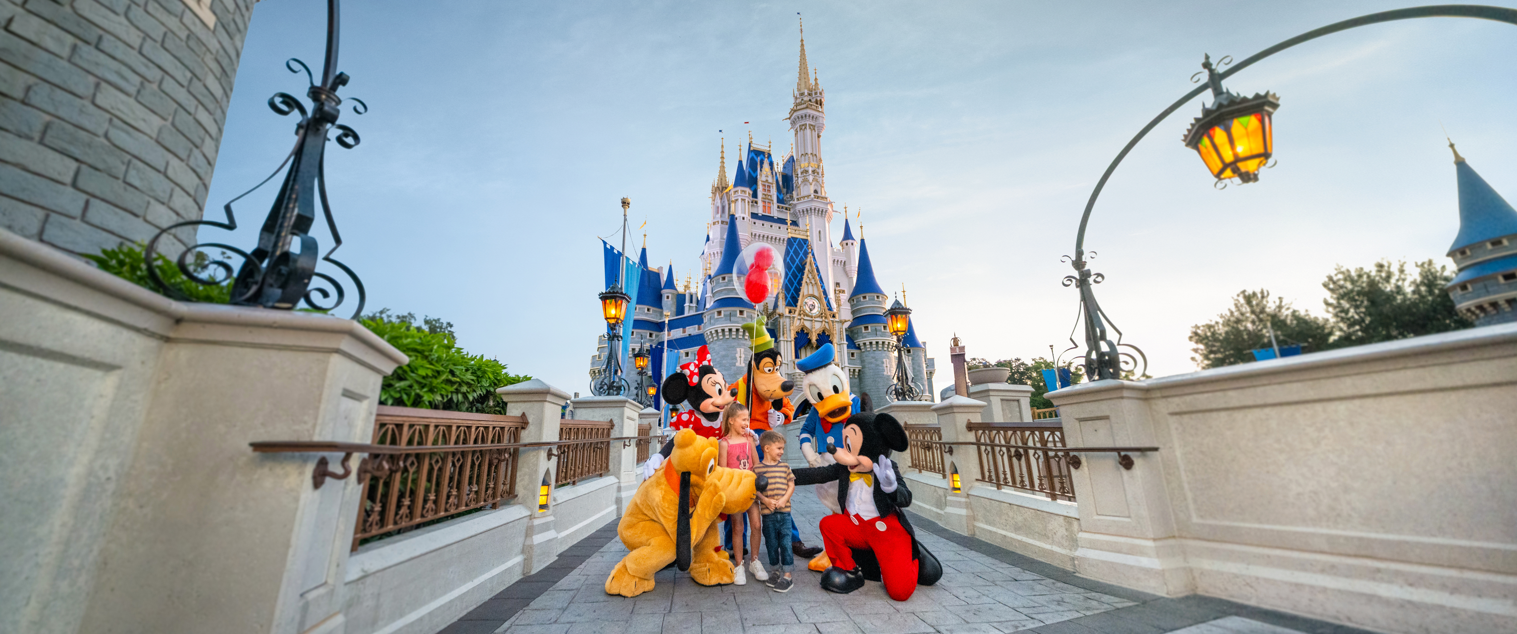 Kids with Mickey Mouse Minnie Goofy Donald and Pluto in front of Cinderella Castle