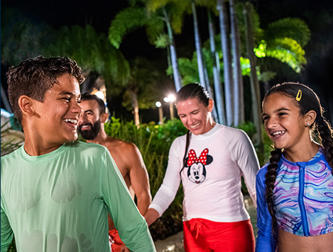 Family laughing at H2O Glow water park night Disney World