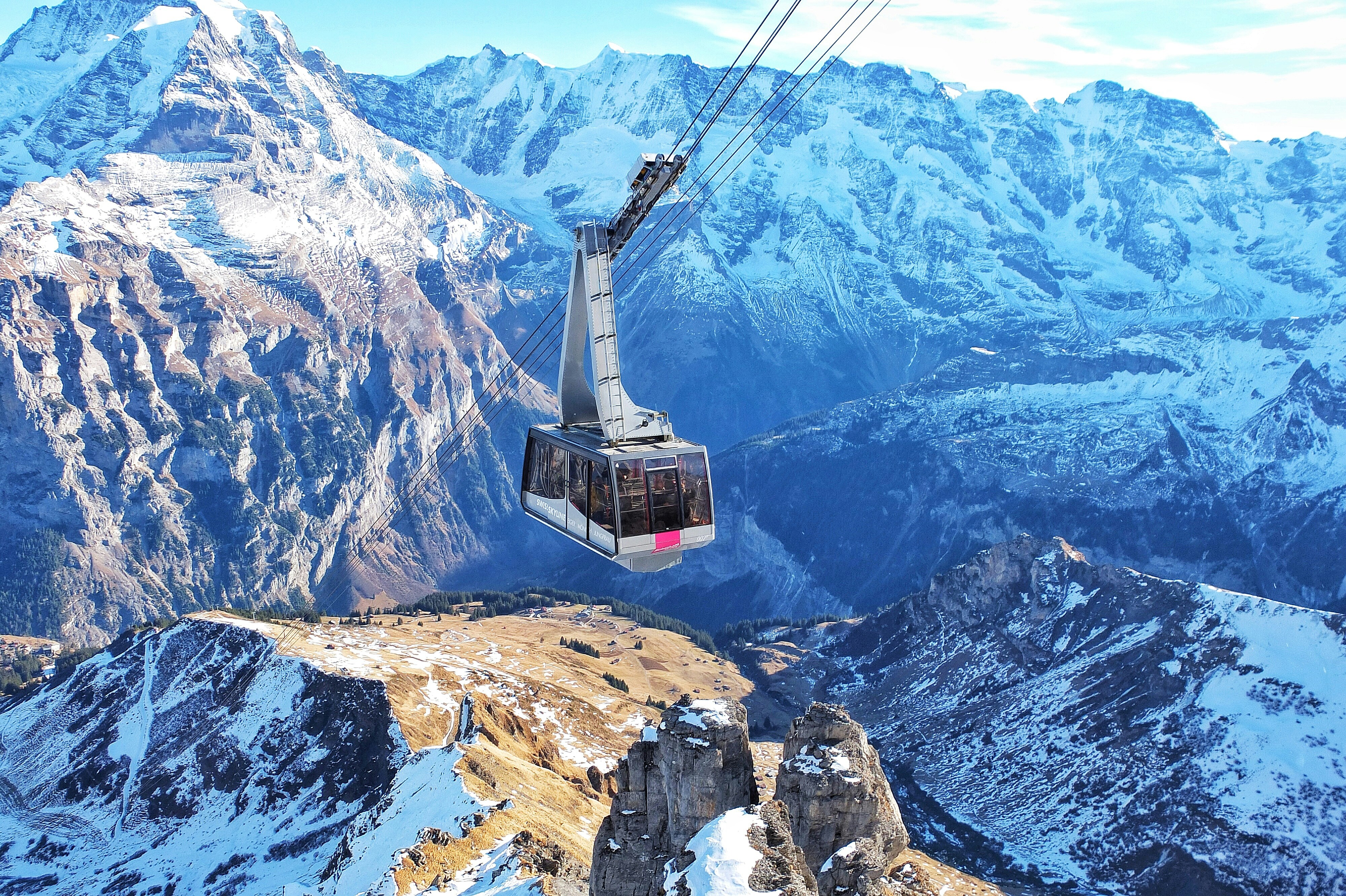 Cable car gondola over snowy Swiss Alps mountain peaks
