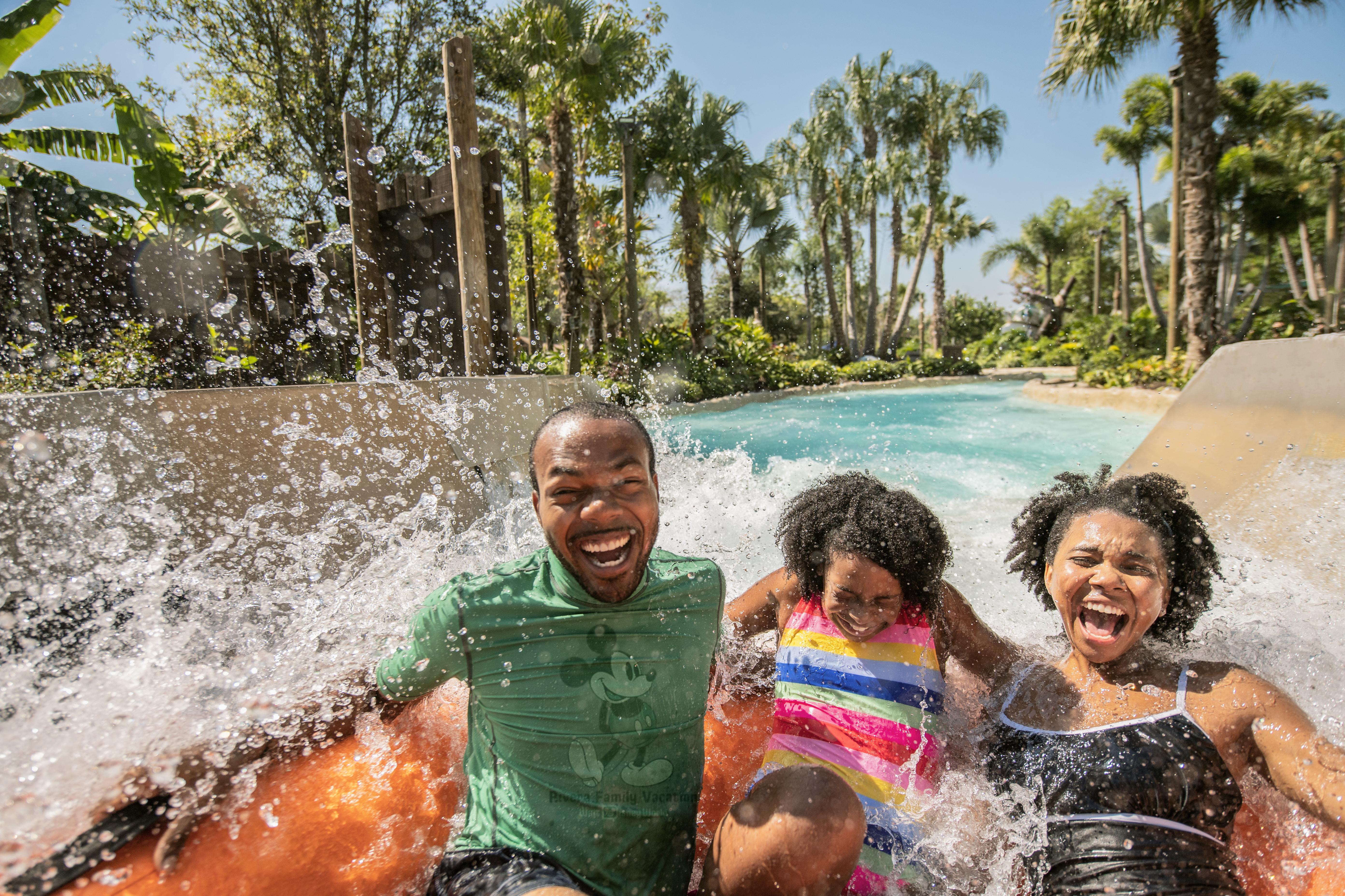 Family laughing on water slide at Disney water park